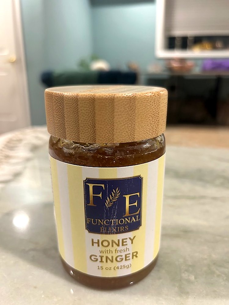 A jar of Functional Elixirs Honey with Fresh Ginger on the kitchen counter at home