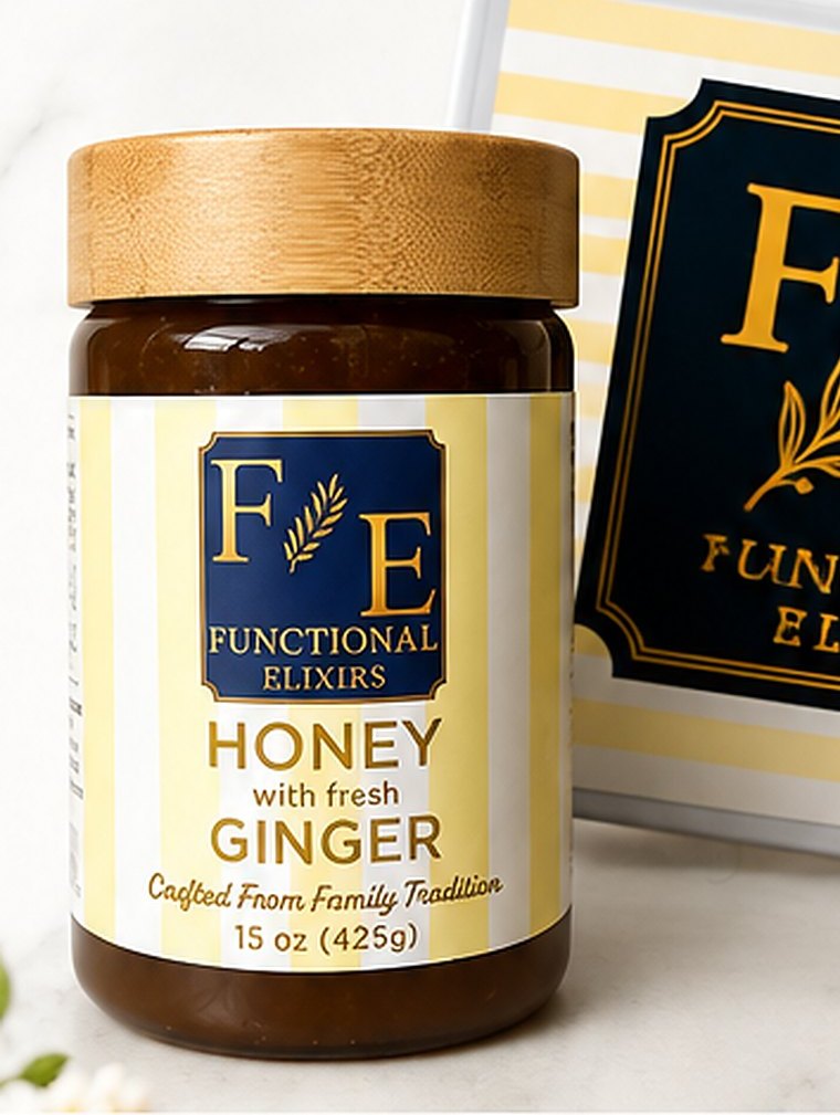 The 15 oz Functional Elixirs Honey with Fresh Ginger jar, bamboo lid on, beside the F·E plaque on marble